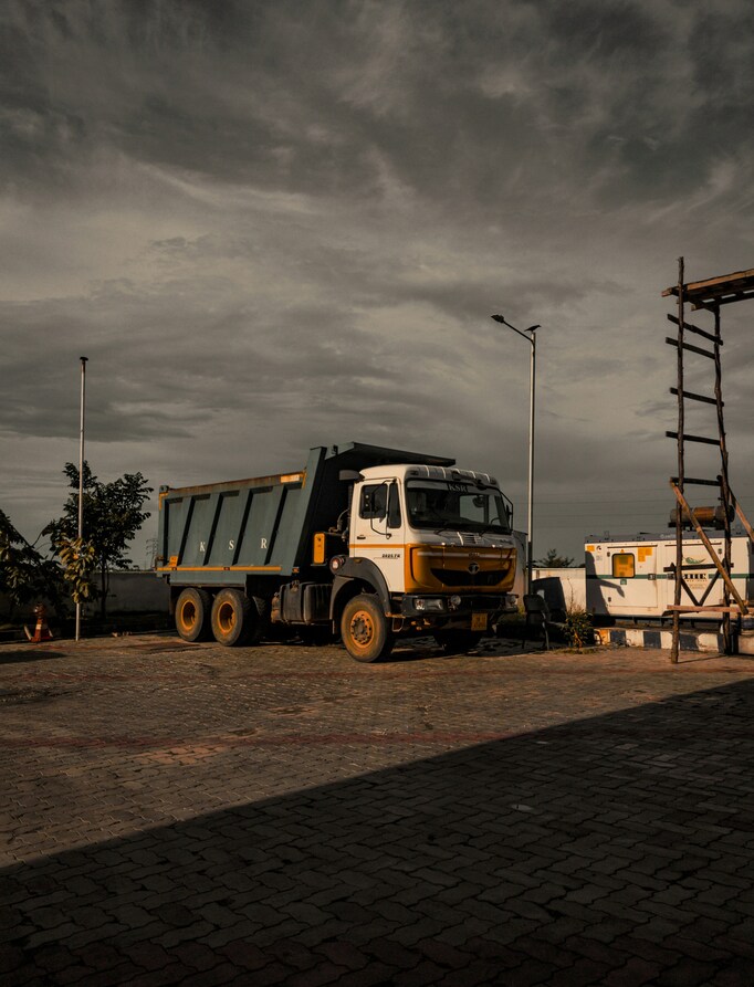 Modern logistics truck parked in a loading area, for load dispatching services, with vibrant company branding and safety markings.